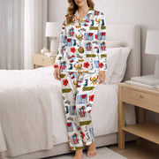 Woman wearing a white long-sleeve button-down pajama set with a colorful, all-over print featuring Puerto Rican cultural symbols like the flag, Coqui frog, Vejigante mask, and 'I love PR' text. The pajamas are made of soft silky satin fabric.