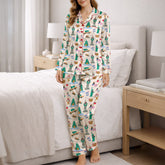 Women's pajama set featuring a whimsical global city print with landmarks like the Statue of Liberty, Empire State Building, Big Ben, and Eiffel Tower, along with urban elements like taxis, pretzels, and coffee cups, on a white background.