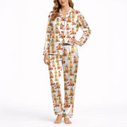 Women's pajama set featuring an all-over print of cute Golden Retrievers in various festive and seasonal outfits, on a white background.