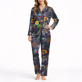Women's pajama set with a vibrant Caribbean-themed pattern featuring Coquí frogs, Salsa hearts, Puerto Rico flag, coffee and rum drinks, palm trees, and cameras on a dark blue background.
