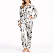 Women's pajama set with a playful black and white ghost pattern, featuring ghosts holding coffee and cocktail glasses, moons, stars, and coffee beans, perfect for comfortable sleepwear.