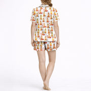 Women's pajama set featuring an all-over print of cute Golden Retrievers in various festive and seasonal outfits, on a white background.