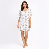Women's cream pajama set with short sleeves and shorts, featuring a playful sepia-toned Dachshund dog print and small star accents.