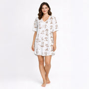 Women's cream pajama set with short sleeves and shorts, featuring a playful sepia-toned Dachshund dog print and small star accents.