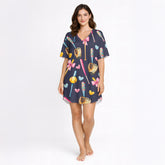 Women's navy blue pajama set with a cute softball and baseball pattern featuring bats, gloves, softballs, hearts, and bows, made from soft knit fabric.