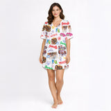 Women's pajama set with a vibrant white background, featuring an all-over print of diverse cartoon girls, pop art text like 'Gabriela' and 'Beautiful Chaos', and various symbols including anchors and crowns, creating a playful and eclectic collage pattern.