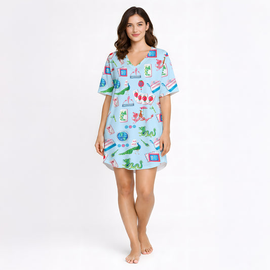 Women's pajama set with whimsical Eastern charm pattern featuring green dragons, pink dragons, peacocks, Mahjong tiles, and 'Charleston' text on a light blue background.