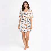 White knit pajama set with an all-over pattern of various colored corgi dogs and paw prints, displayed on a white background.