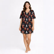 Women's Christmas pajama set featuring a festive pattern of cute Highland cows wearing Santa hats and plaid scarves, with white Christmas trees and snowflakes on a black background. The set includes a short-sleeve button-down top and matching shorts.