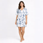 Women's pajama set with a blue sketch-style pattern of horses, horseshoes, and saddles on a white background, made from soft knit fabric.