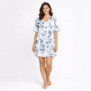 Women's pajama set with a blue sketch-style pattern of horses, horseshoes, and saddles on a white background, made from soft knit fabric.