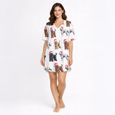 Women's white knit pajama set with an all-over Christmas print of curly-haired dogs wearing Santa hats and tangled in colorful string lights.