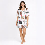 Women's white knit pajama set with an all-over Christmas print of curly-haired dogs wearing Santa hats and tangled in colorful string lights.