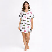 Women's pajama set featuring a 'Wicked' themed pattern with witch hats, pink bows, green bows, and pink dresses on a light background, made from soft knit fabric.