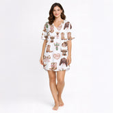 Women's white pajama set with a cute cowgirl print featuring pink bows, cowboy boots, Highland cows, and cacti, made from soft knit fabric.
