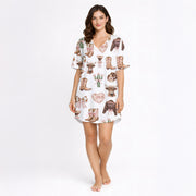 Women's white pajama set with a cute cowgirl print featuring pink bows, cowboy boots, Highland cows, and cacti, made from soft knit fabric.