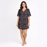 Women's short sleeve button down pajama set with shorts featuring a dark celestial and botanical print of moths, crescent moons, and pink flowers on a black background.