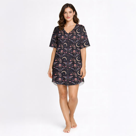 Women's short sleeve button down pajama set with shorts featuring a dark celestial and botanical print of moths, crescent moons, and pink flowers on a black background.