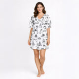 Women's pajama set featuring a black and white hand-drawn wedding doodle pattern with brides, grooms, cakes, rings, and champagne glasses on a white background, perfect for bridal loungewear.