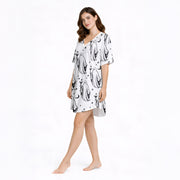 Women's pajama set with a playful black and white ghost pattern, featuring ghosts holding coffee and cocktail glasses, moons, stars, and coffee beans, perfect for comfortable sleepwear.
