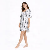 Women's pajama set with a playful black and white ghost pattern, featuring ghosts holding coffee and cocktail glasses, moons, stars, and coffee beans, perfect for comfortable sleepwear.