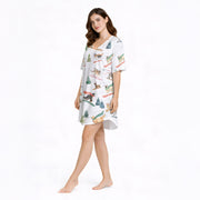 White knit pajama set with a playful pattern of various dog breeds skiing and snowboarding down snowy slopes, surrounded by evergreen trees, perfect for winter and holiday season.