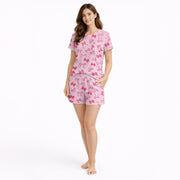 Pink pajama set with short sleeve button-down top and shorts, featuring an all-over cute bow pattern, perfect for women's sleepwear.