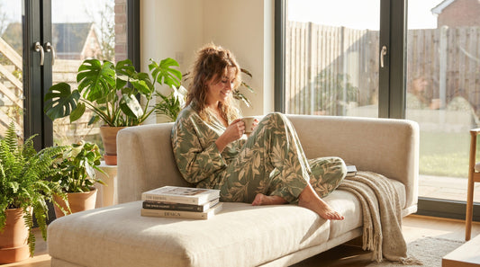 Woman wearing stylish lounge set for women relaxing at home in natural light