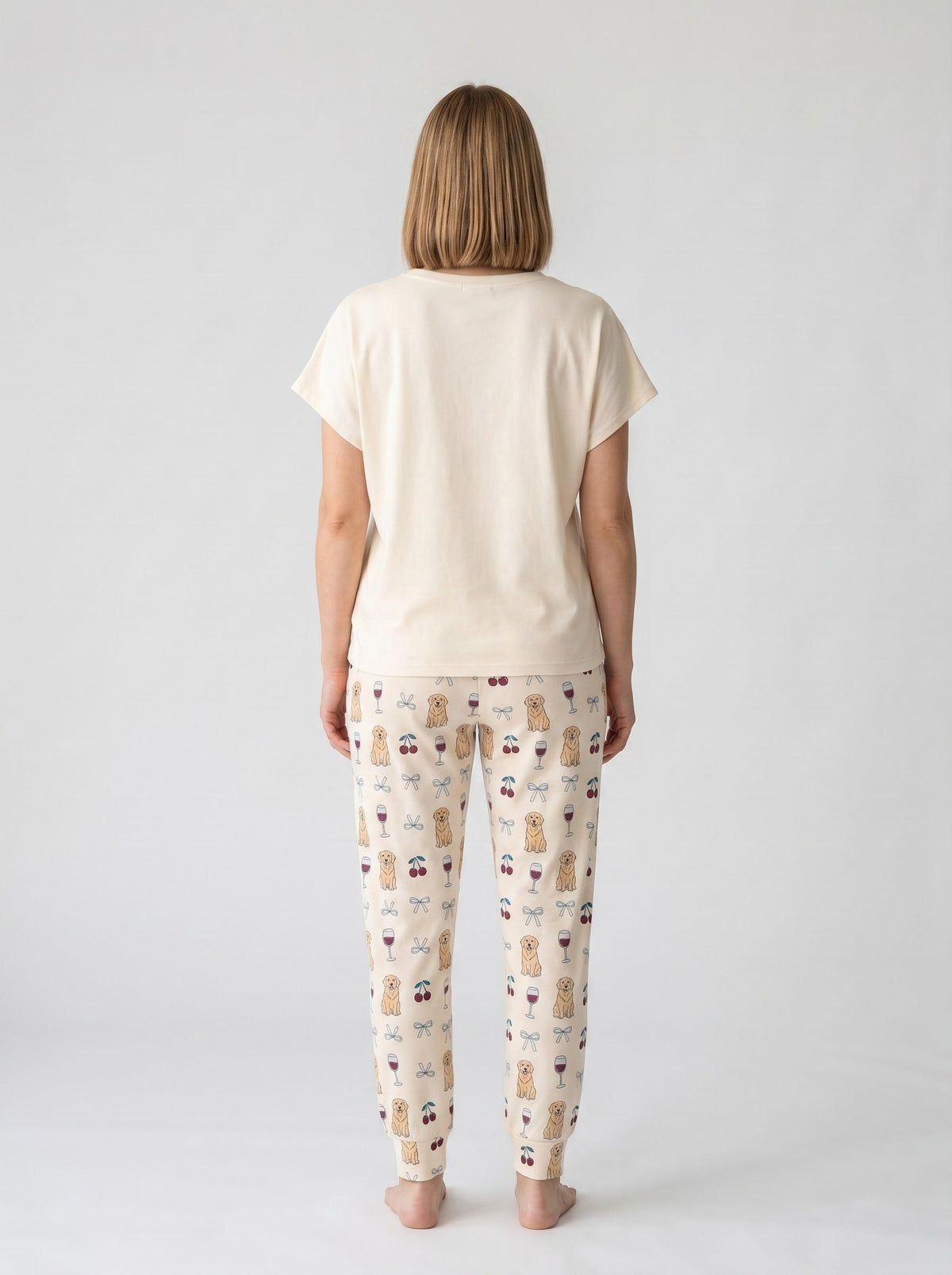 Cream soft knit pajama set with cartoon golden retriever Wine Not graphic tee and matching all-over print jogger pants