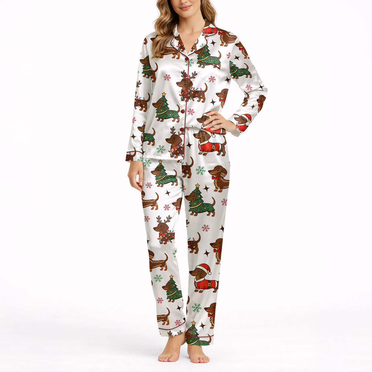 A woman wearing a white short sleeve pajama set with shorts, featuring a festive Christmas pattern of cartoon dachshunds dressed as Santa, reindeer, and Christmas trees. The pajamas have red piping.