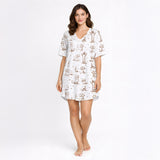 Women's cream pajama set with short sleeves and shorts, featuring a playful sepia-toned Dachshund dog print and small star accents.