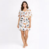 White knit pajama set with an all-over pattern of various colored corgi dogs and paw prints, displayed on a white background.