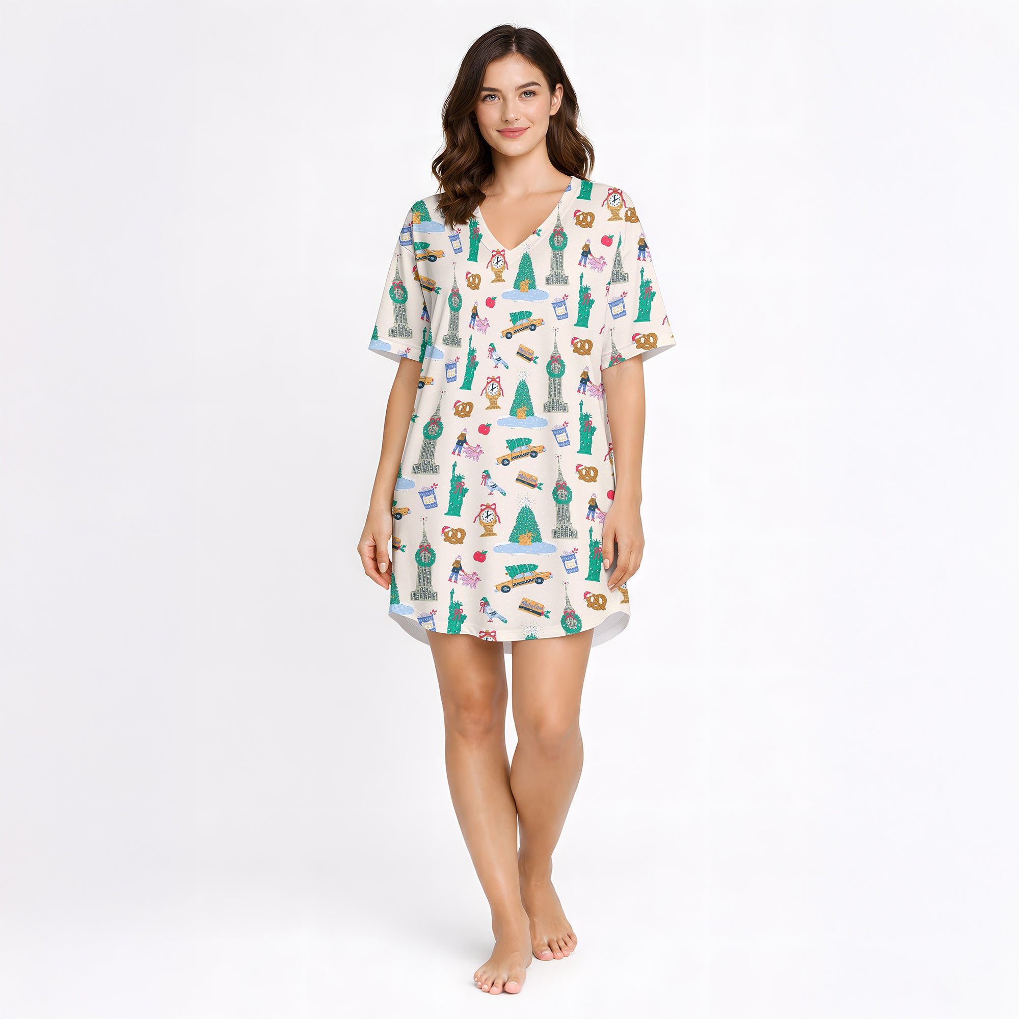 Women's pajama set featuring a whimsical global city print with landmarks like the Statue of Liberty, Empire State Building, Big Ben, and Eiffel Tower, along with urban elements like taxis, pretzels, and coffee cups, on a white background.