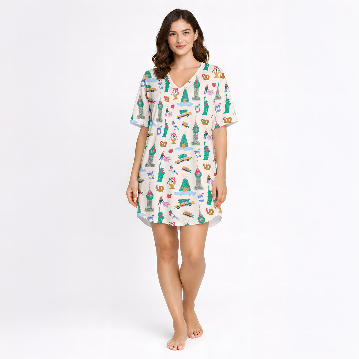 Women's pajama set featuring a whimsical global city print with landmarks like the Statue of Liberty, Empire State Building, Big Ben, and Eiffel Tower, along with urban elements like taxis, pretzels, and coffee cups, on a white background.