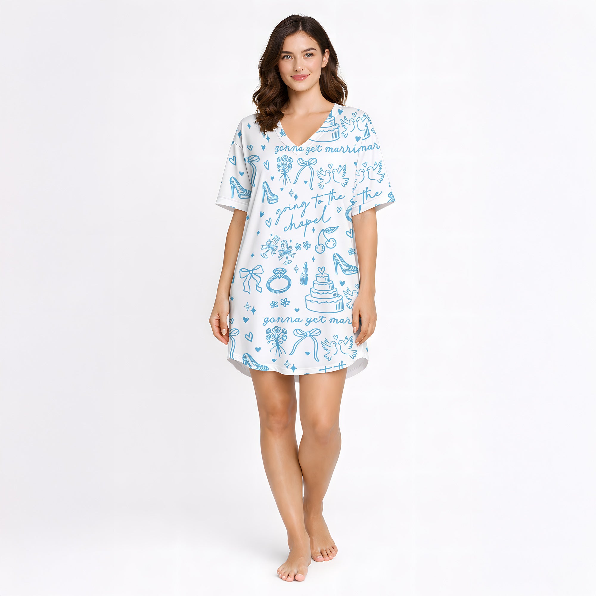 Woman wearing a white and light blue wedding-themed pajama set with short sleeves and shorts, holding a white mug. The pajama set features doodles of wedding cakes, rings, doves, and text 'going to the chapel' and 'gonna get married'.