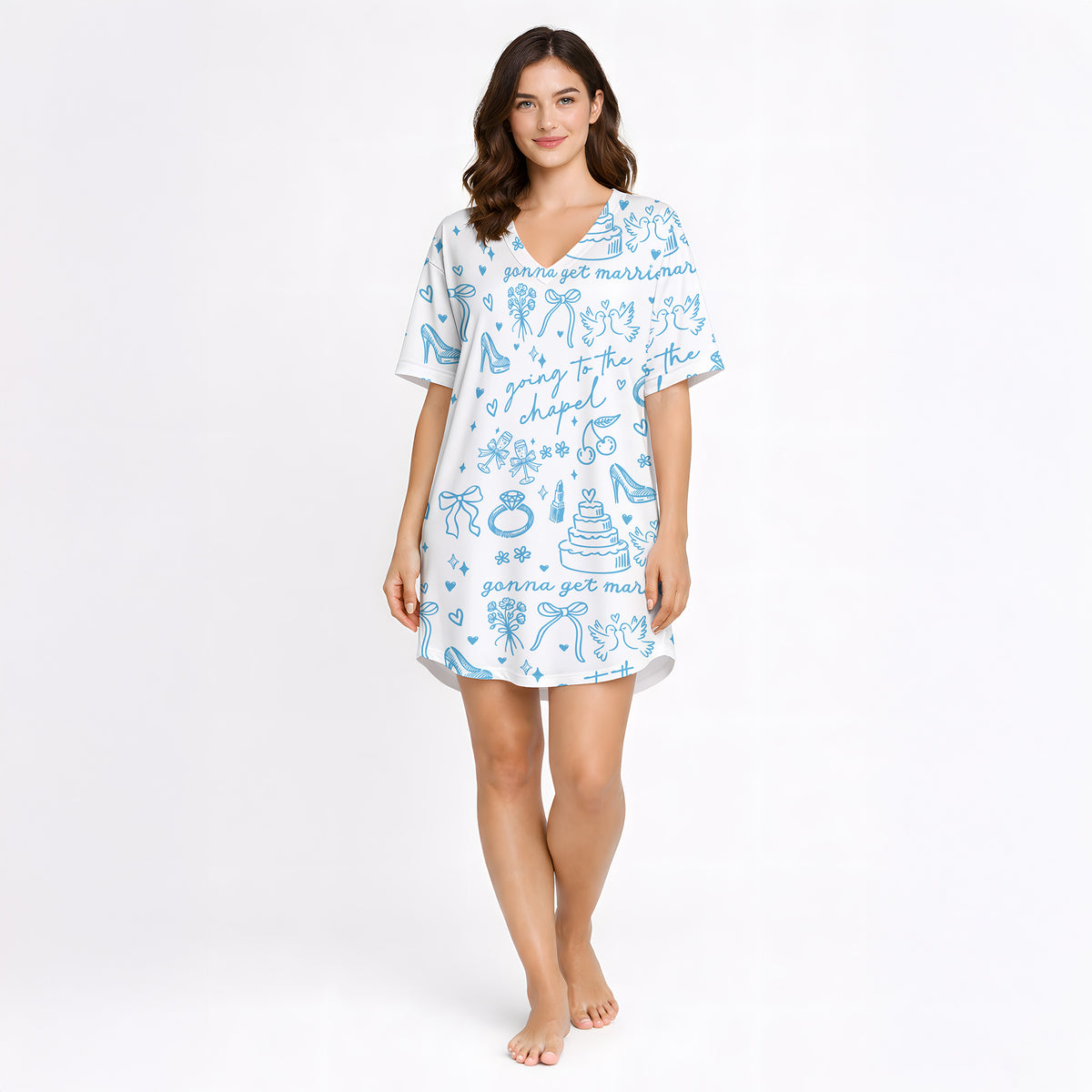 Woman wearing a white and light blue wedding-themed pajama set with short sleeves and shorts, holding a white mug. The pajama set features doodles of wedding cakes, rings, doves, and text 'going to the chapel' and 'gonna get married'.