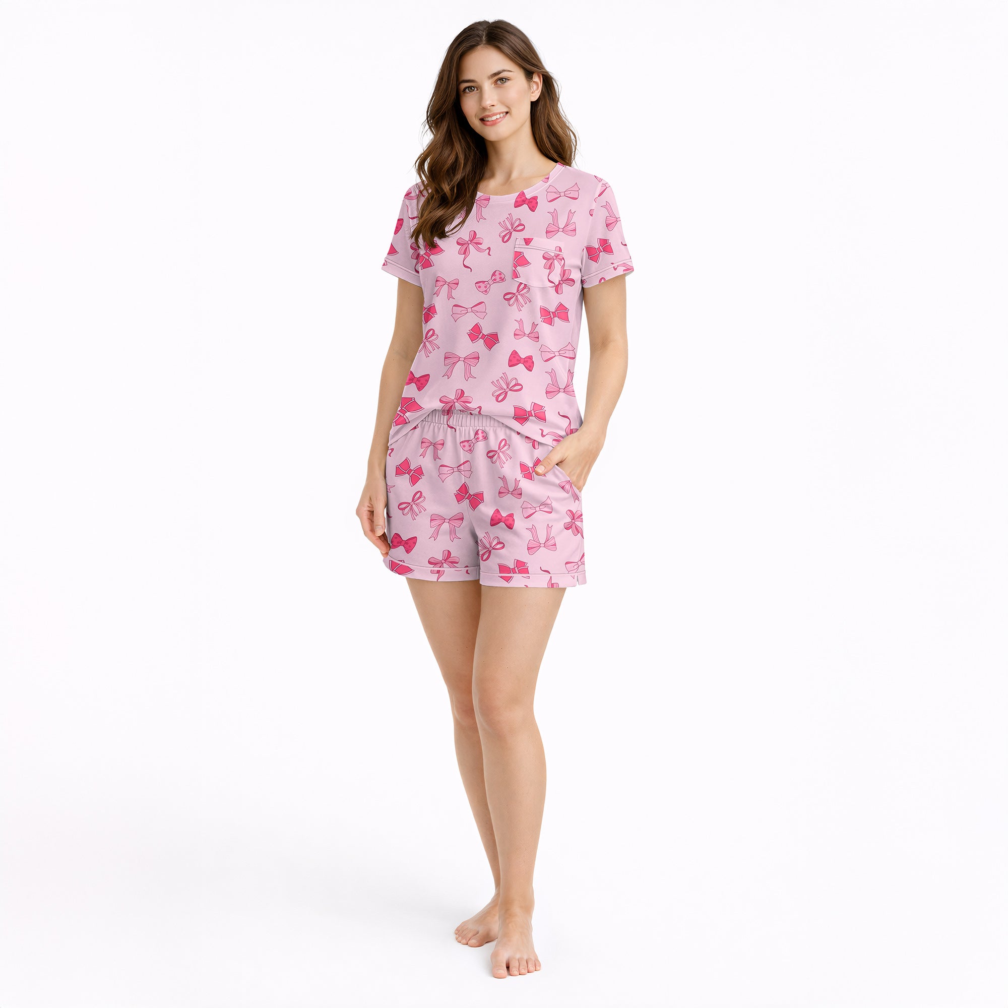 Pink pajama set with short sleeve button-down top and shorts, featuring an all-over cute bow pattern, perfect for women's sleepwear.