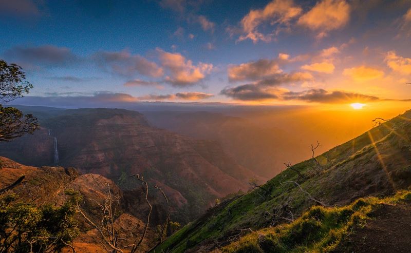 Waimea Canyon transforms into a canvas of light and shadows during sunrise